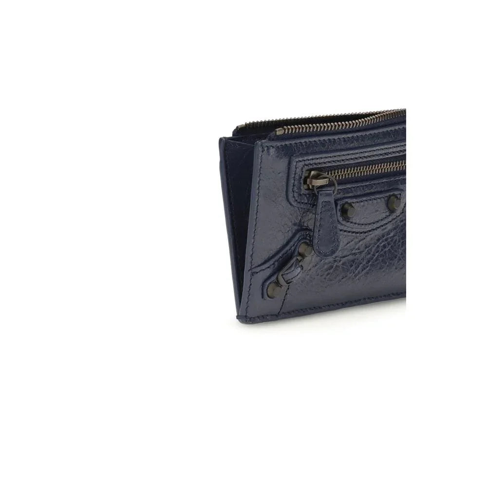 Close-up of a navy blue leather wallet with zipper and stud details on a white background.