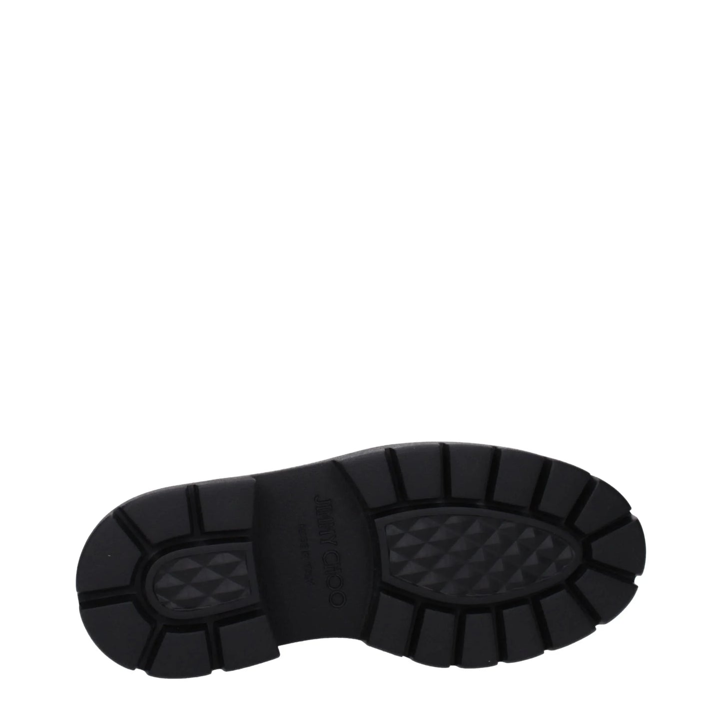 Black chunky rubber sole of a designer boot with textured tread pattern on white background
