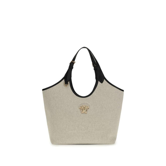 Beige canvas tote bag with black leather handles and gold Medusa head accent, luxury accessory