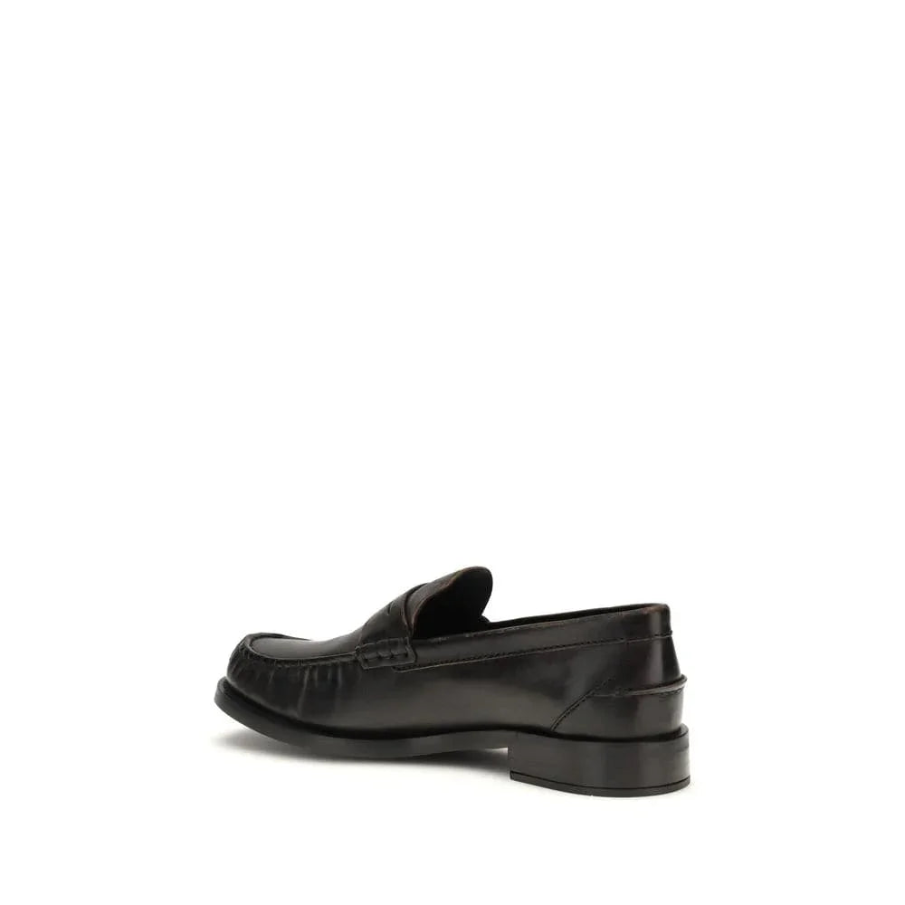 Black leather loafer with low heel and classic stitching, side profile view on white background