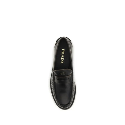 Black leather designer loafer shoe top view, classic slip-on style, minimal white background