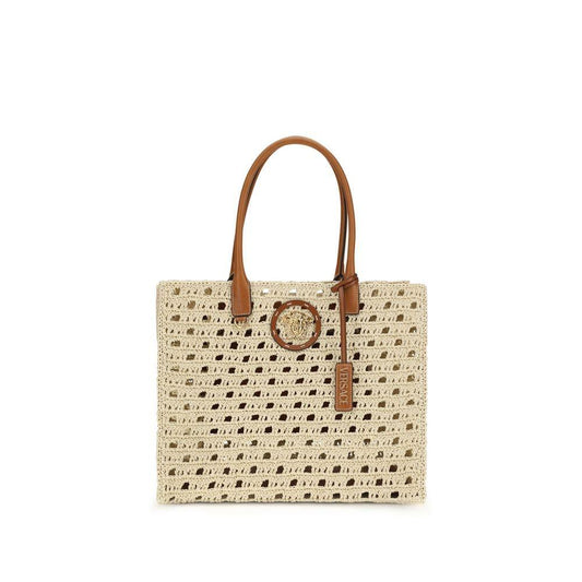 Beige woven straw tote bag with brown leather handles and gold medallion accent