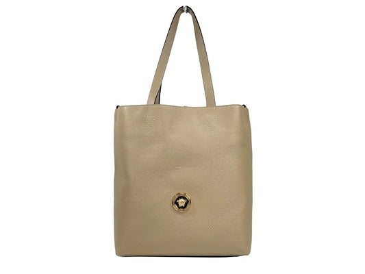 Beige leather tote bag with gold medallion detail and double handles on white background