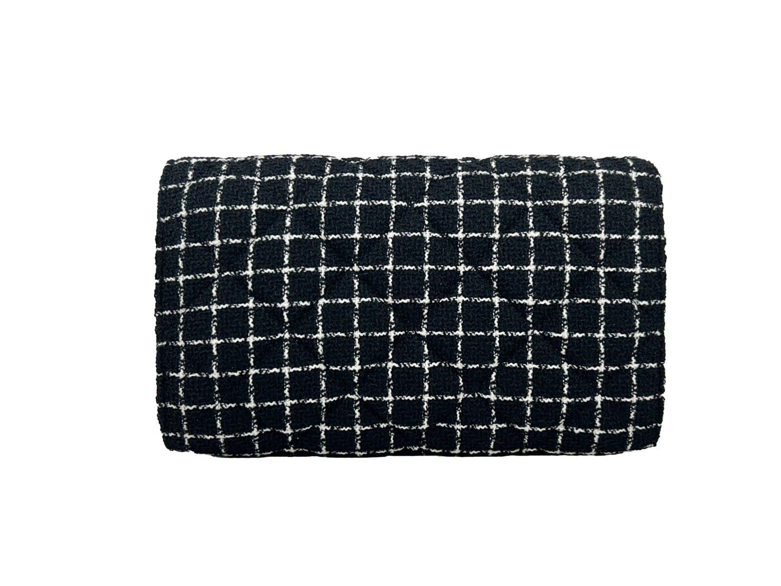 Black and white tweed clutch bag with grid pattern on white background
