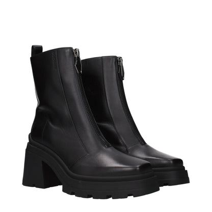 Black chunky-heel leather ankle boots with front zipper and lug sole on white background