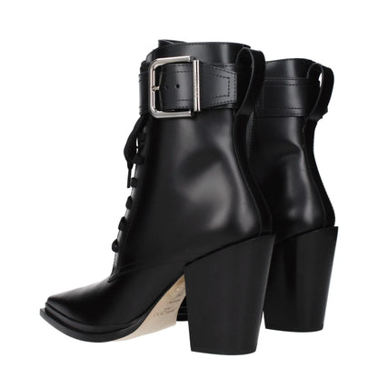 Black leather ankle boots with block heels, silver buckle strap, and lace-up design