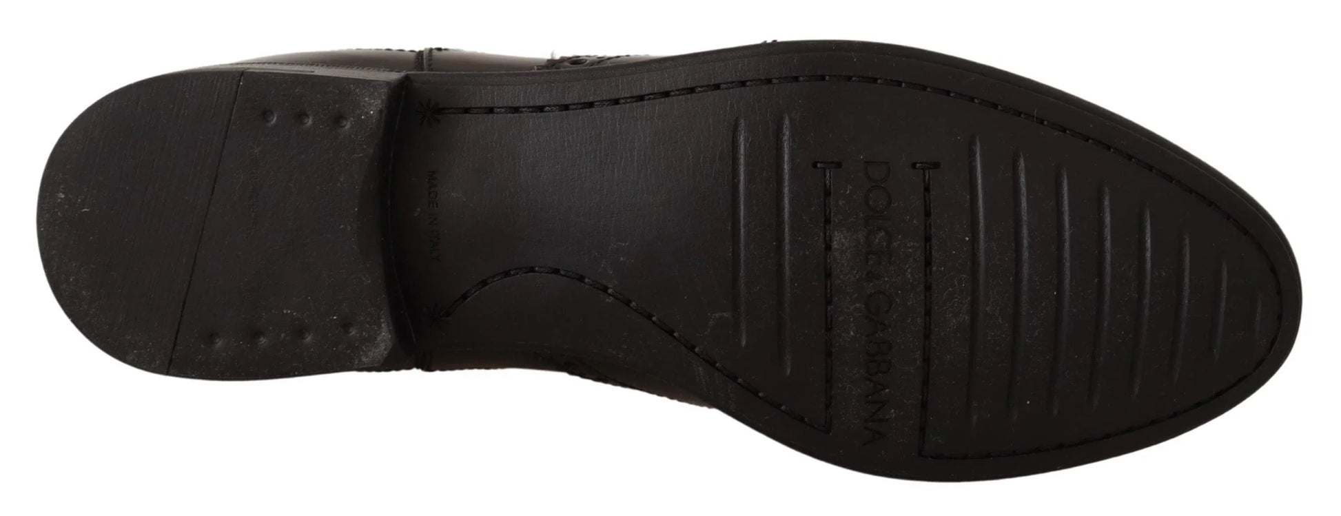 Bottom view of black leather dress shoe sole with stitched detail and textured grip