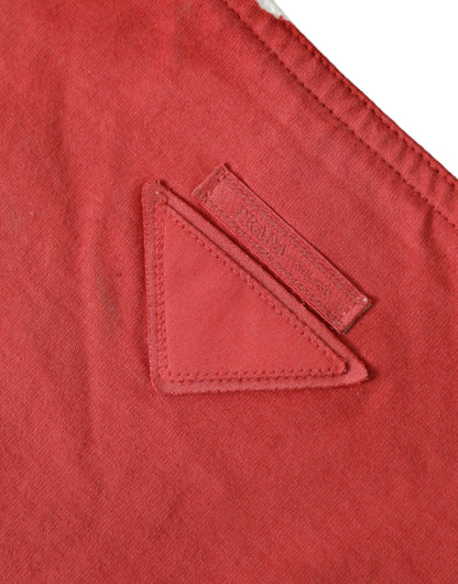 Close-up of a red cotton fabric with a stitched triangular detail and tag accent