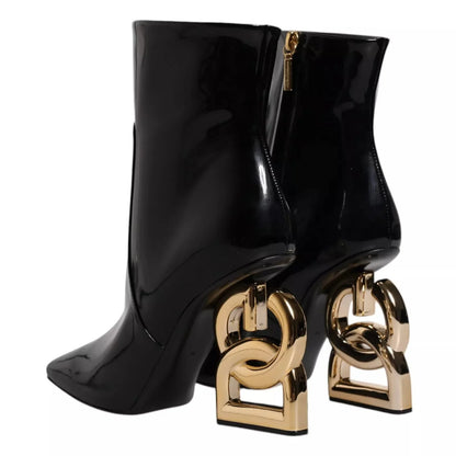 Black patent leather ankle boots with sculptural gold heels and side zippers, luxury footwear