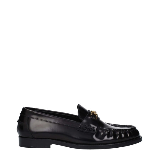 Black leather loafer with gold-toned horsebit detail on a white background