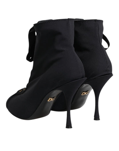 Black stiletto sock boots with gold logo heel detail and pointed toe, luxury footwear