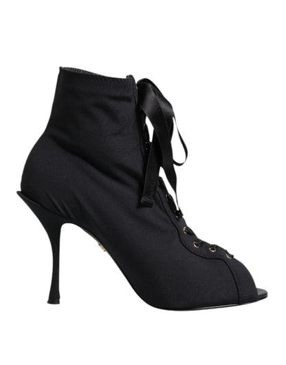 Black lace-up stiletto ankle boot with peep toe and ribbon laces on white background