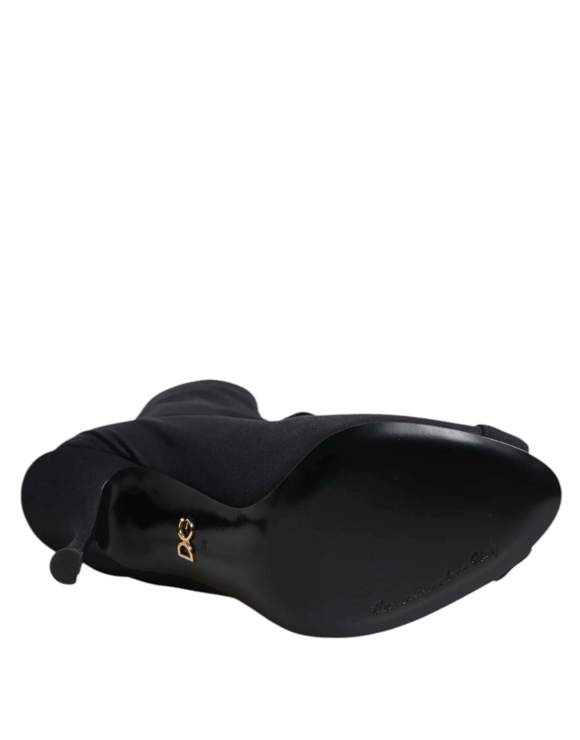 Black high-heeled boot viewed from the sole with gold D&G logo and pointed toe