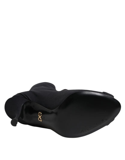 Black high-heeled boot viewed from the sole with gold D&G logo and pointed toe