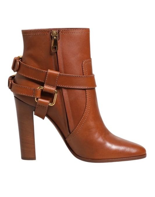 Brown leather high heel ankle boot with gold buckles and side zipper on white background