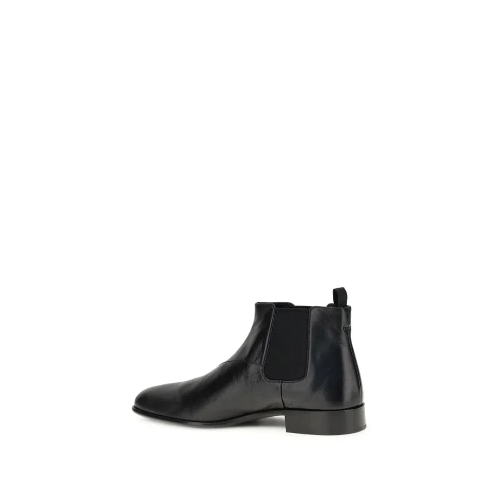 Black leather Chelsea boot with elastic side panel and pull tab on white background