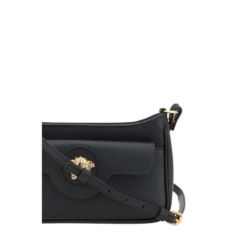 Black leather crossbody bag with gold lion head emblem and adjustable strap