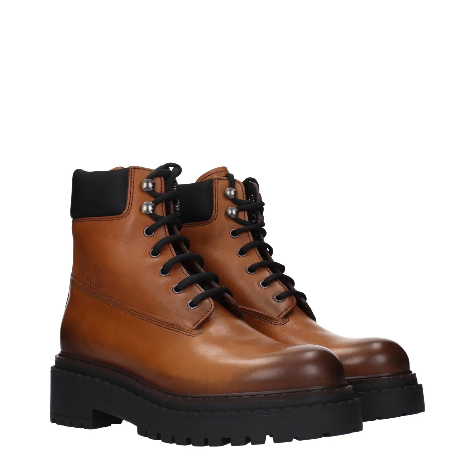 Brown leather lace-up ankle boots with black chunky rubber sole and padded collar