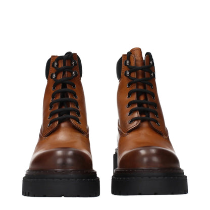 Brown leather lace-up combat boots with black soles, front view, on white background
