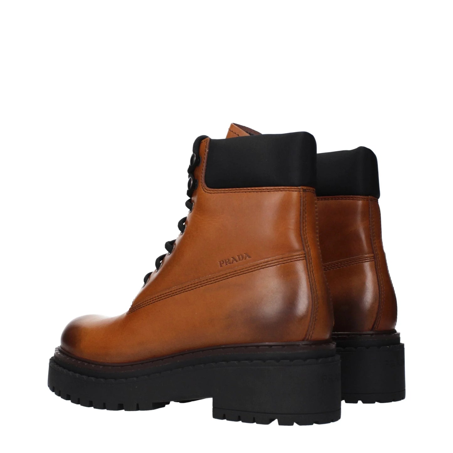Brown leather ankle boots with black chunky soles and lace-up design, luxury footwear