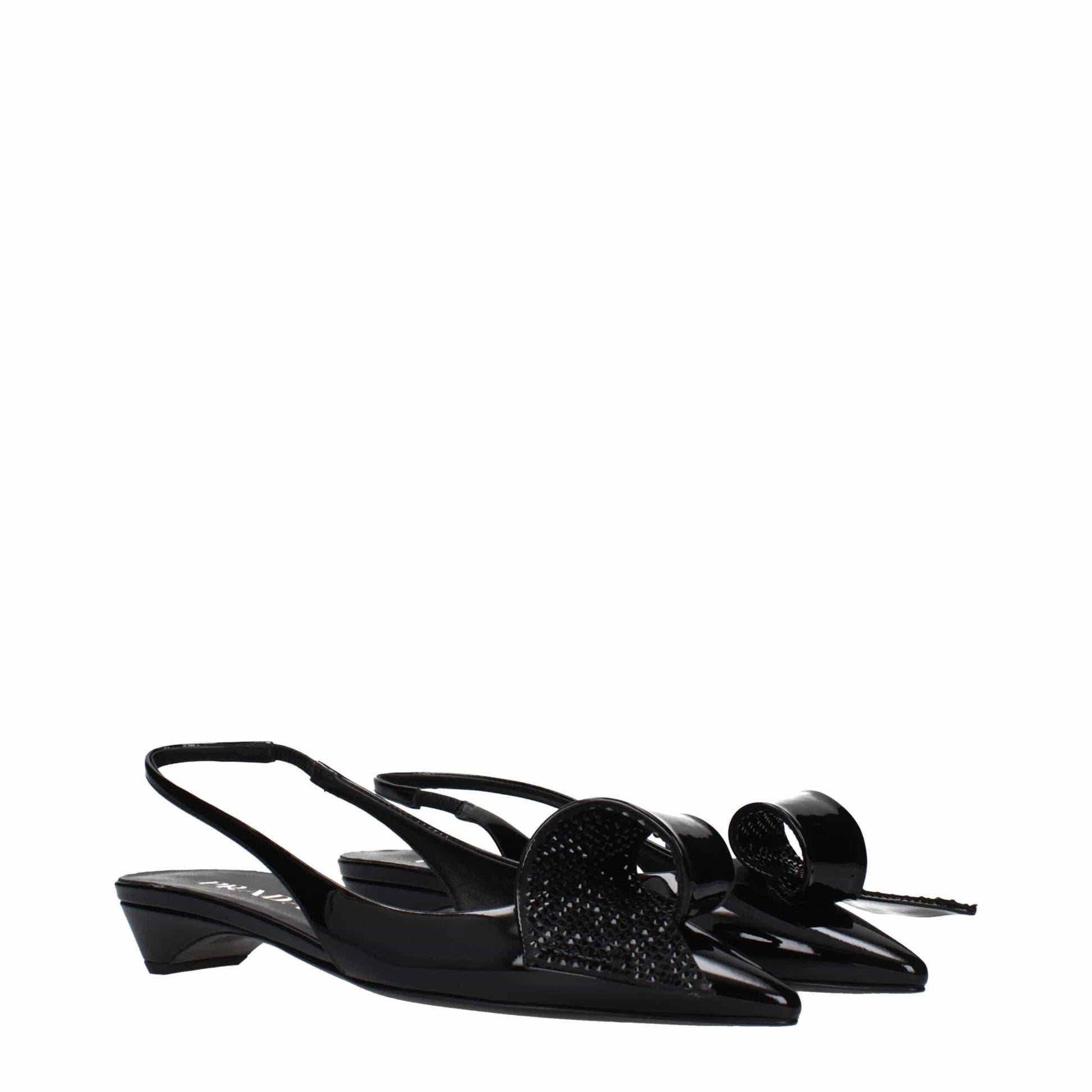 Black slingback kitten heel shoes with pointed toes and bow details on white background