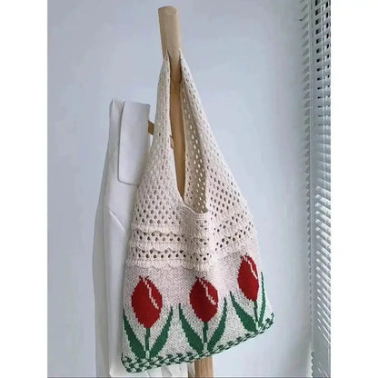 Beige crochet tote bag with red tulip flower knit pattern, hanging on a hook