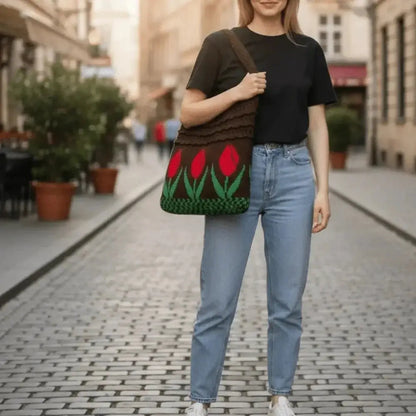 Woman carrying a colorful hippie crochet knitted tote bag with red tulip pattern on city street