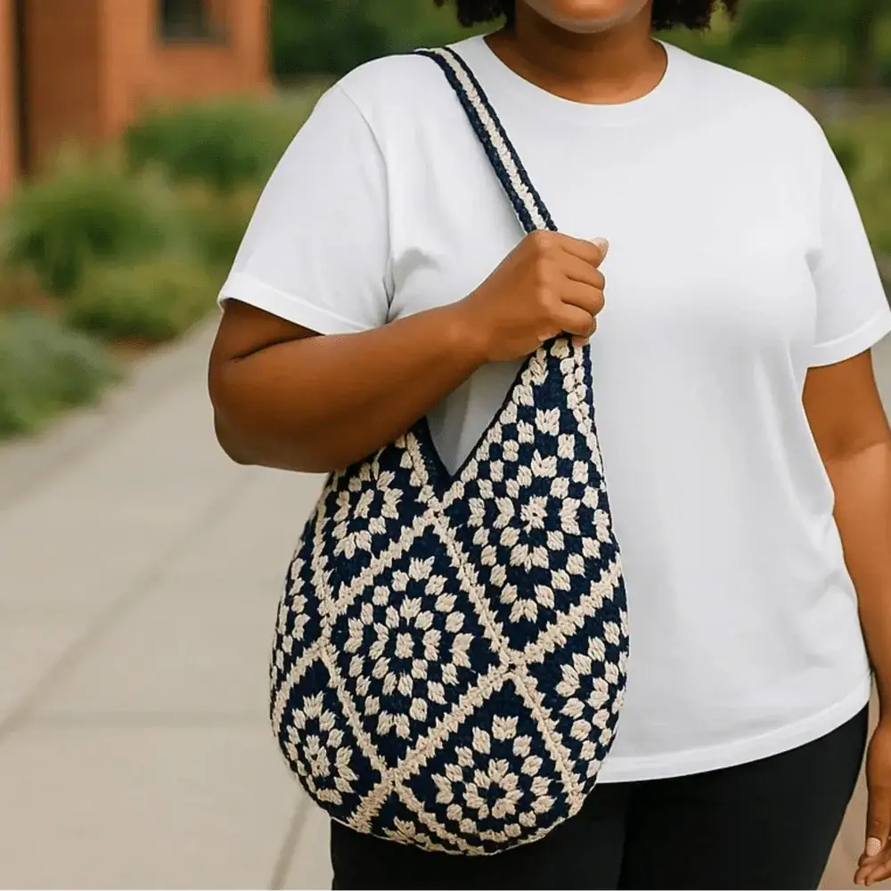 Hand-woven cotton yarn shoulder bag with geometric pattern, held by woman outdoors