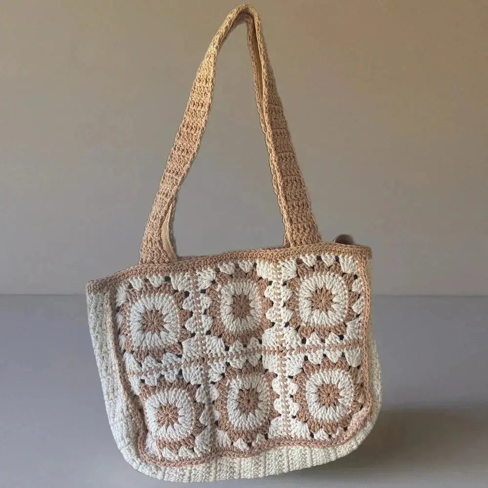 Handmade crochet tote bag with beige and cream cotton yarn in boho style on plain background