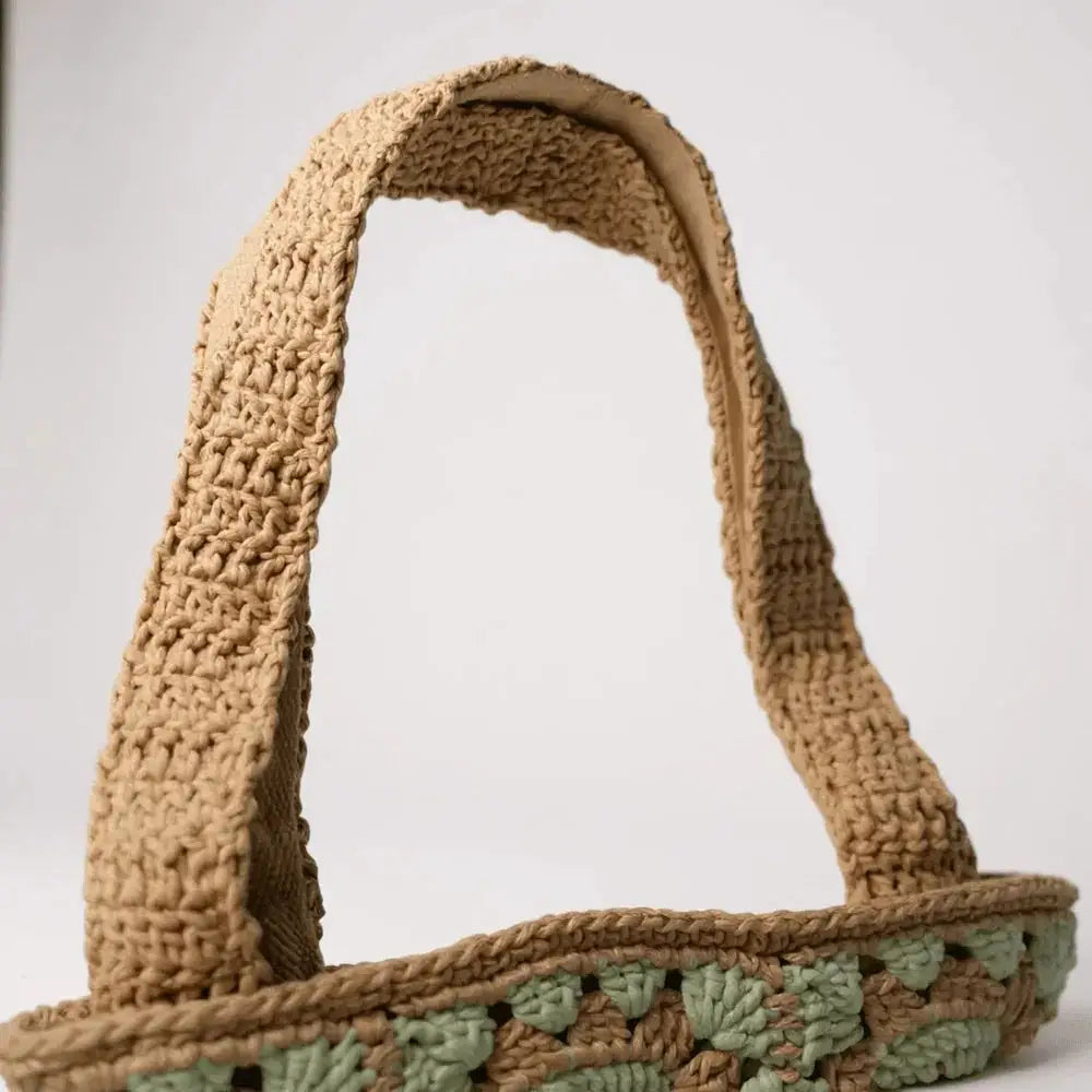Handmade crochet tote bag with wide beige cotton yarn strap and green accent pattern