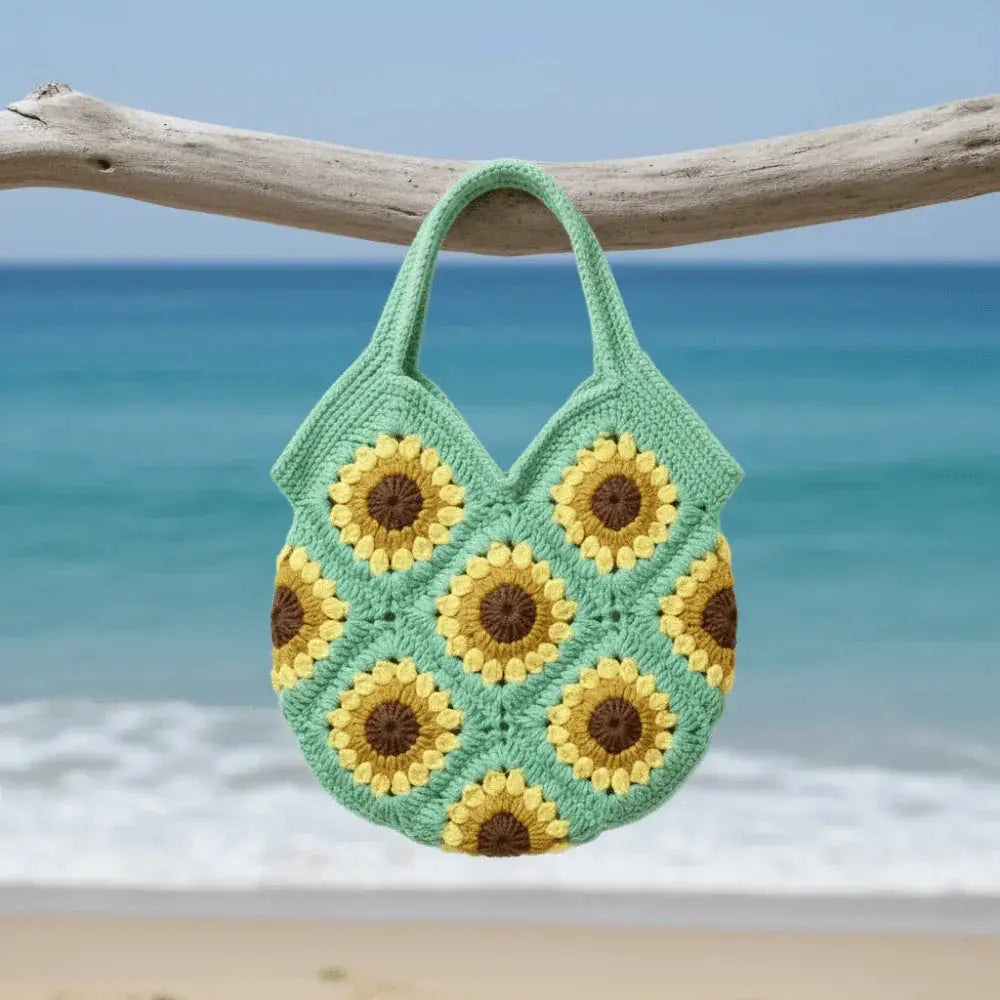 Handmade sunflower crochet cotton bag with boho design hanging by the beach