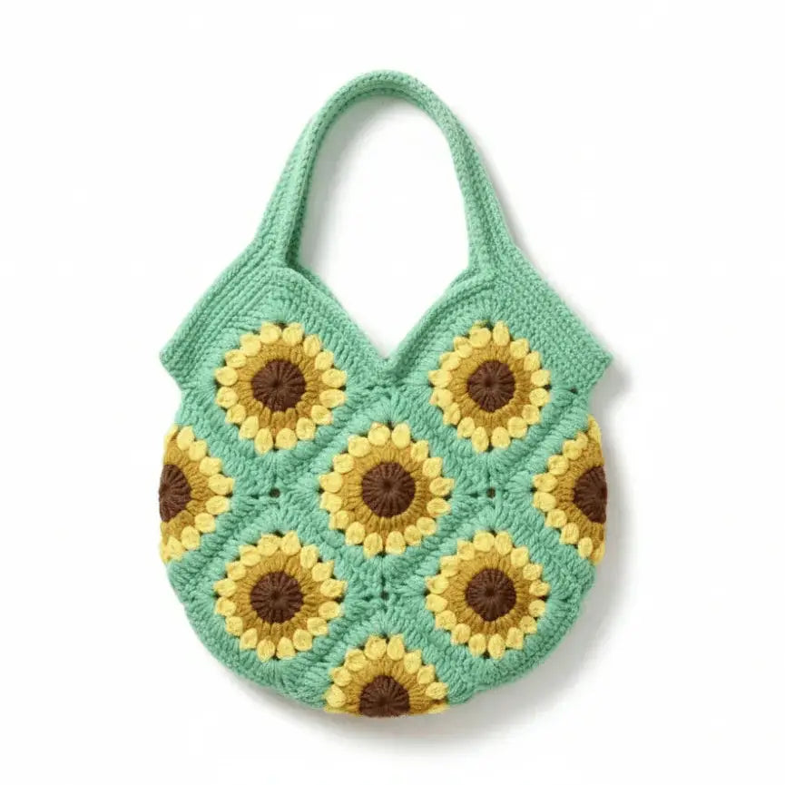 Handmade boho crochet bag with yellow sunflower patterns and green cotton yarn.