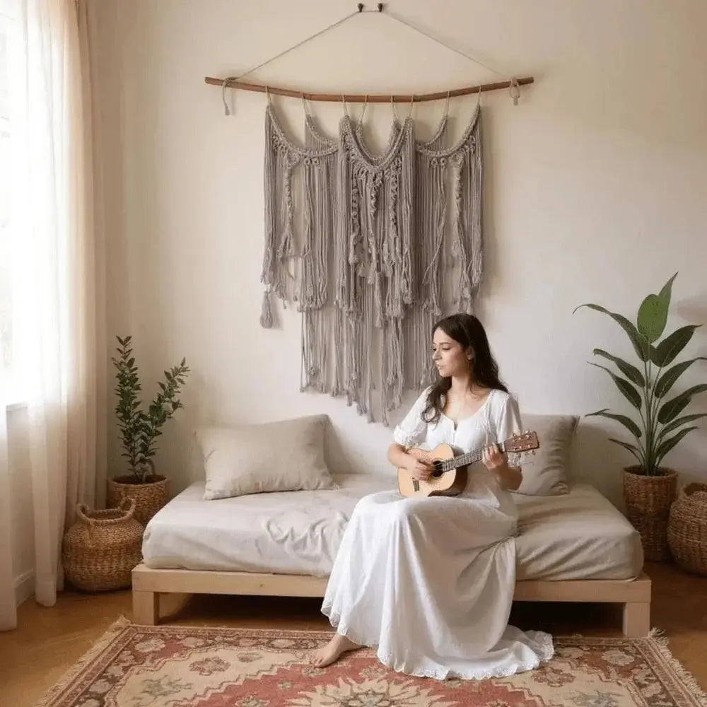 Boho macrame wall hanging above sofa in cozy, minimalist living room with woman playing guitar