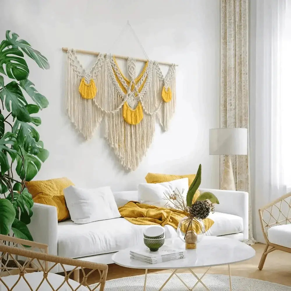 Large boho macrame wall hanging in natural cotton with yellow accents above modern sofa