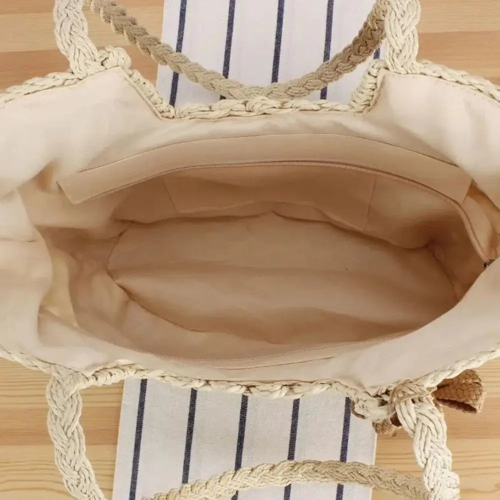Interior of large handmade woven straw beach bag with braided handles and zip pocket
