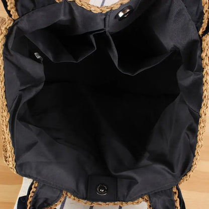 Interior view of woven raffia tote bag with black fabric lining and inner pockets