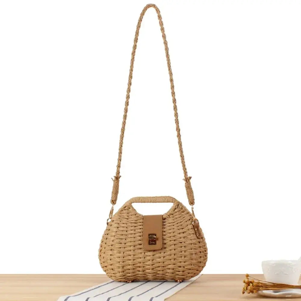 Woven straw box crossbody bag with top handle, leather clasp, and braided shoulder strap