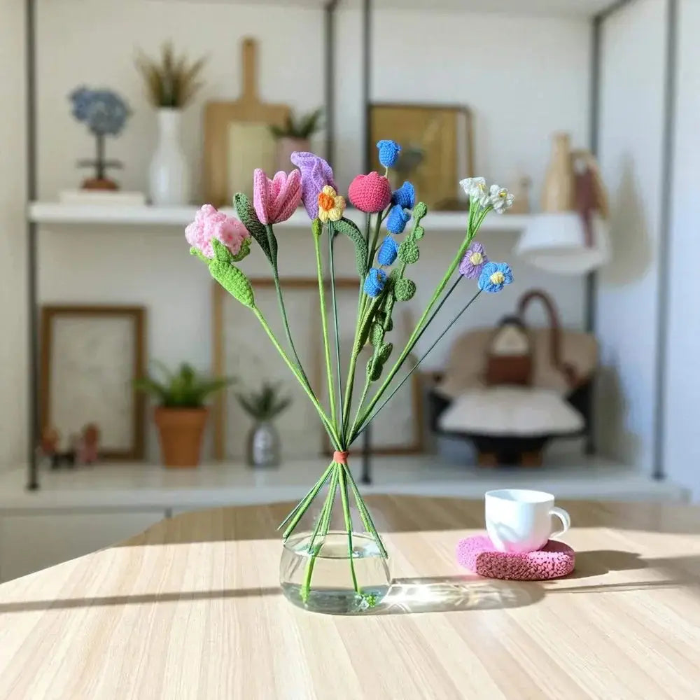 Handmade crochet flower bouquet with colorful yarn flowers in a glass vase on a table